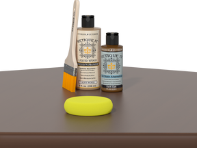 Retique It® Dark Oak Kit with Light Wood’n Primer, Dark Oak Gel Stain Alternative, paintbrush, and yellow sponge on a dark oak tabletop.