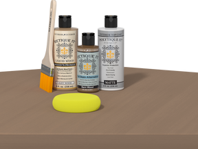 Retique It® Barn Wood Multipurpose Kit contents with Light Wood Liquid Wood primer, Barn Wood gel stain alternative, PolyTique It® matte exterior top coat, paintbrush, and yellow sponge displayed on a wood surface.