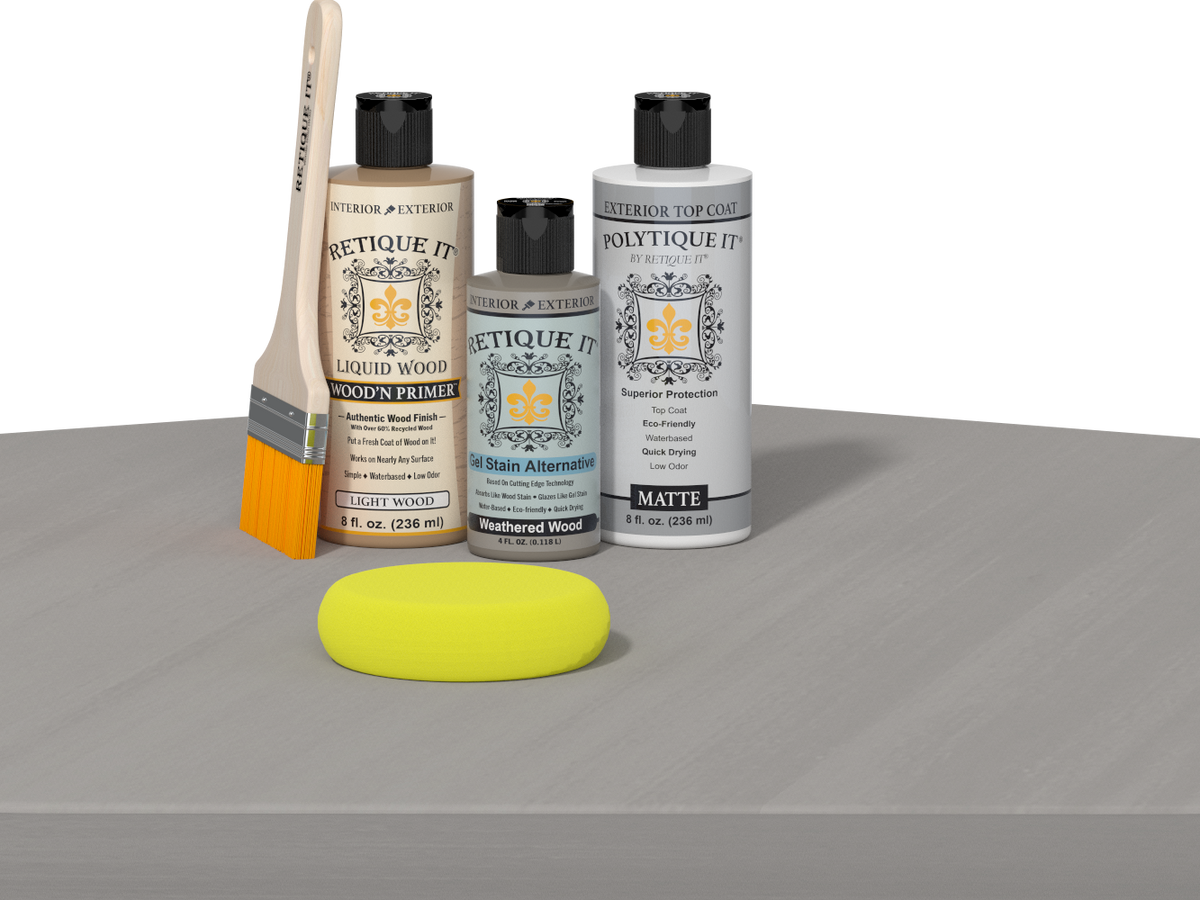 Retique It® Weathered Wood Multipurpose Kit contents with Light Wood Liquid Wood primer, Weathered Wood gel stain alternative, PolyTique It® matte exterior top coat, paintbrush, and yellow sponge displayed on a gray wood surface.