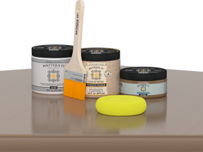 Retique It Barn Wood Kit with Gloss Polytique It, Light Wood Wood'n Primer, Barn Wood Gel Stain Alternative, paintbrush, and yellow sponge on a tabletop.