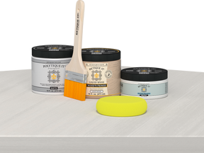 Retique It® White Wash Multipurpose Kit contents with Liquid Wood primer, White Wash gel stain alternative, PolyTique It® matte exterior top coat, paintbrush, and yellow sponge displayed on a white wood surface.