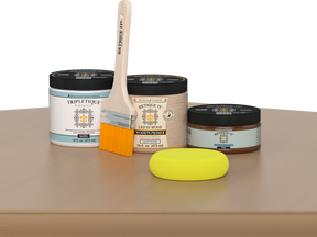 Retique It® Pecan Multipurpose Kit contents with Light Wood Liquid Wood primer, Pecan gel stain alternative, Tripletique satin interior top coat, paintbrush, and yellow sponge displayed on a wood surface.