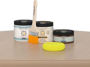 Retique It® White Oak Multipurpose Kit contents with Liquid Wood primer, Pecan gel stain alternative, Tripletique satin interior top coat, paintbrush, and yellow sponge displayed on a light wood surface.