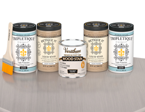 64 oz Retique It Liquid Wood kit with Antique White stain, satin Tripletique topcoat, and a paintbrush on a matching finished tabletop.